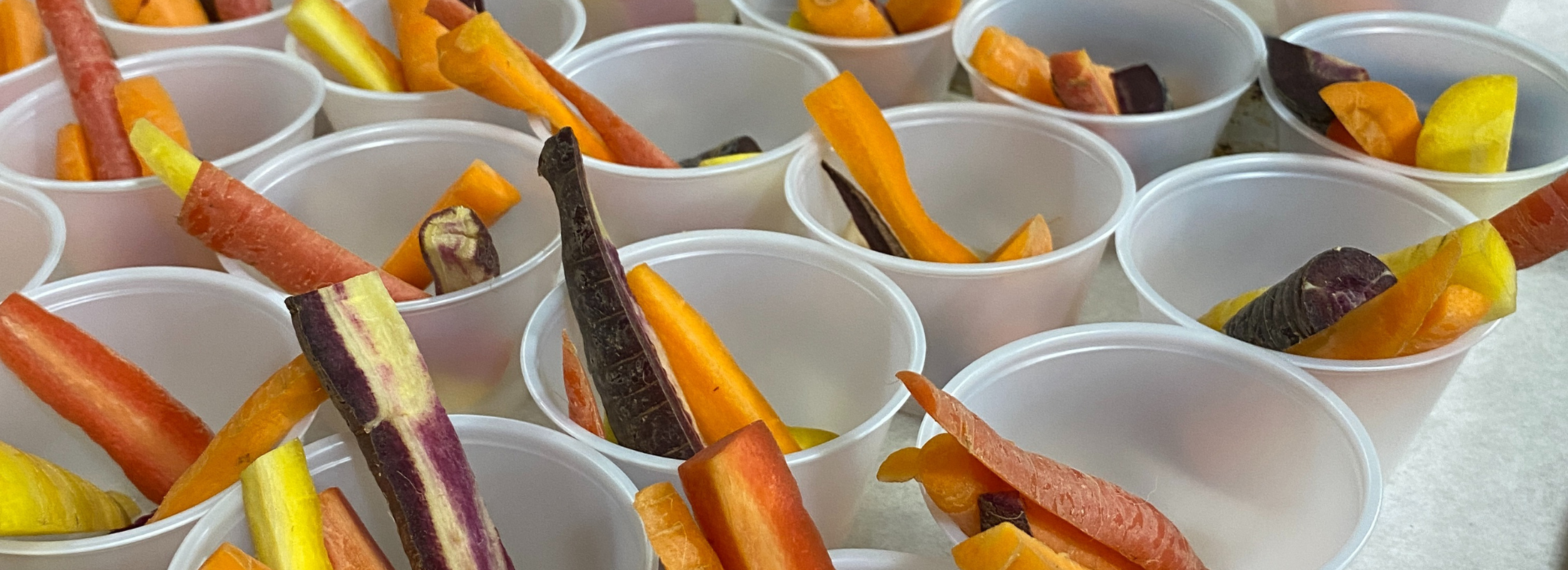 Cups filled with sticks of rainbow carrots