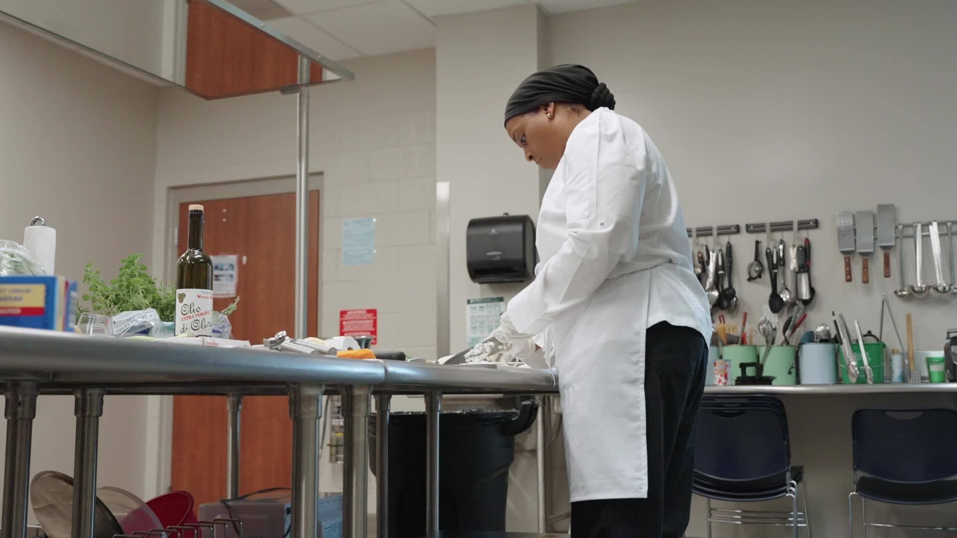woman in a chef's coat preparing food in a kitchen