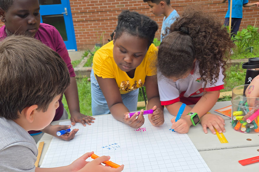students graphing plant growth on paper