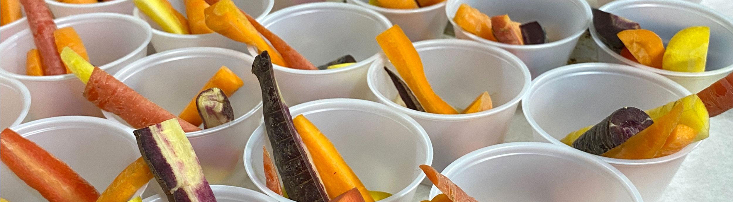 Cups filled with sticks of rainbow carrots