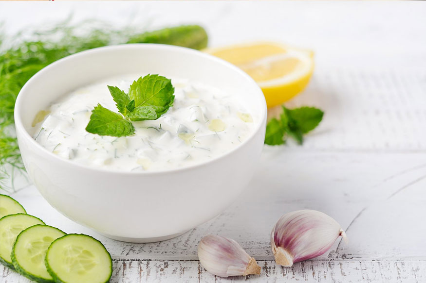 yogurt dip in a white bowl with the ingredients that make up the dip